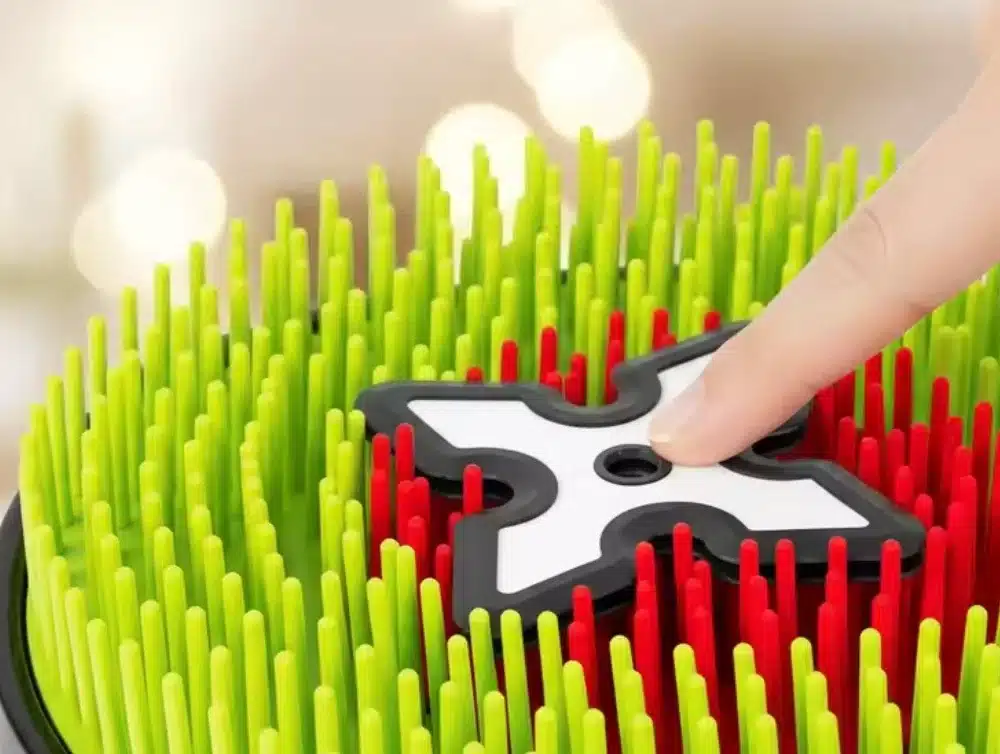 Main d'enfant enfonçant les picots souples de la cible de lancer interactive