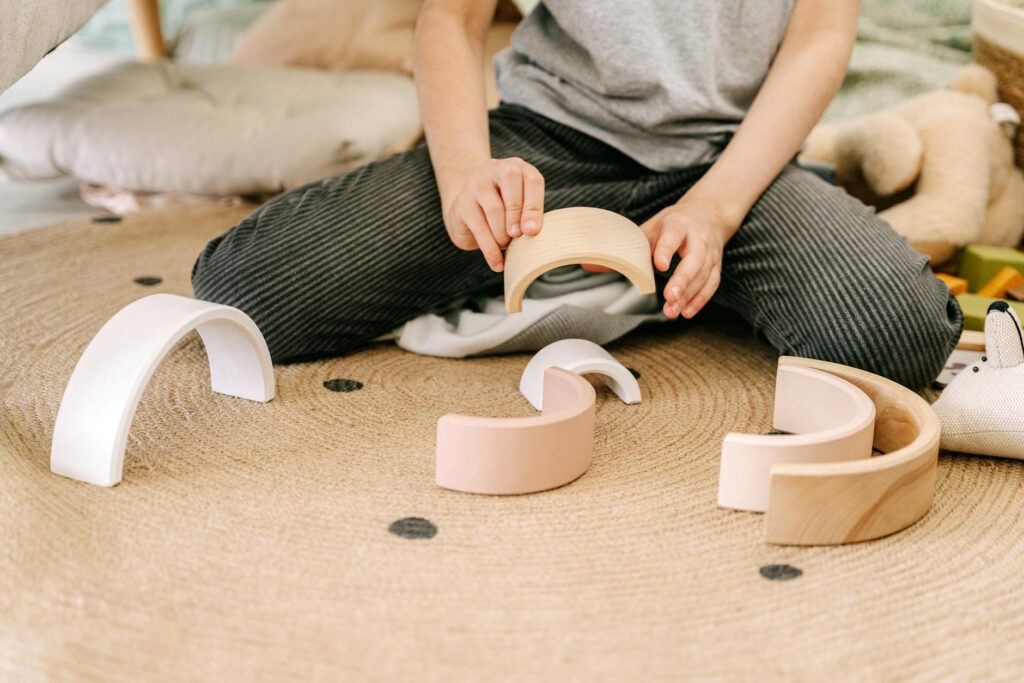Enfant de quatre ans concentré sur un jeu de construction en bois coloré