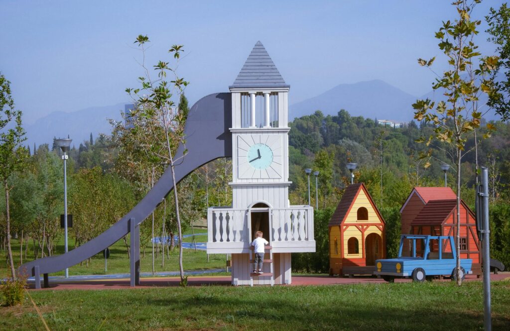 Enfants jouant sur une aire de jeu en bois dans un jardin verdoyant