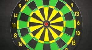 Joueur de fléchettes professionnel concentré devant une cible lors d'un tournoi