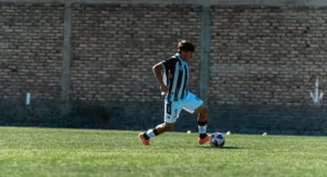 Crampons plastique Nike vissés sur chaussure de football, gros plan terrain mouillé