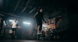 Un sportif en action qui saute à la corde sur un sol de gym