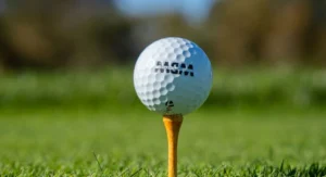 Un support pour balle de golf aligné sur un green face à un joueur concentré