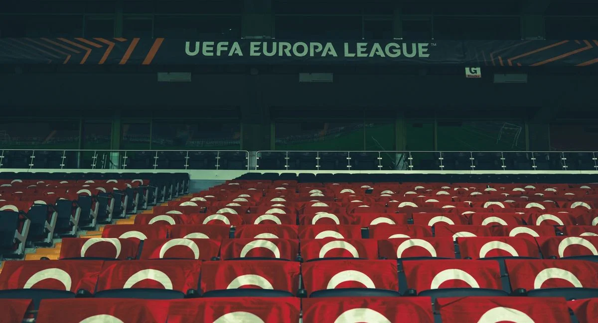 Rows of empty stadium seats adorned with UEFA Europa League banners, creating a sporting event atmosphere.