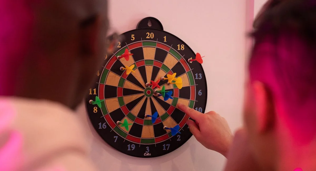 Two people engaging in a dart game with vibrant magnetic darts, focusing on accuracy and fun.