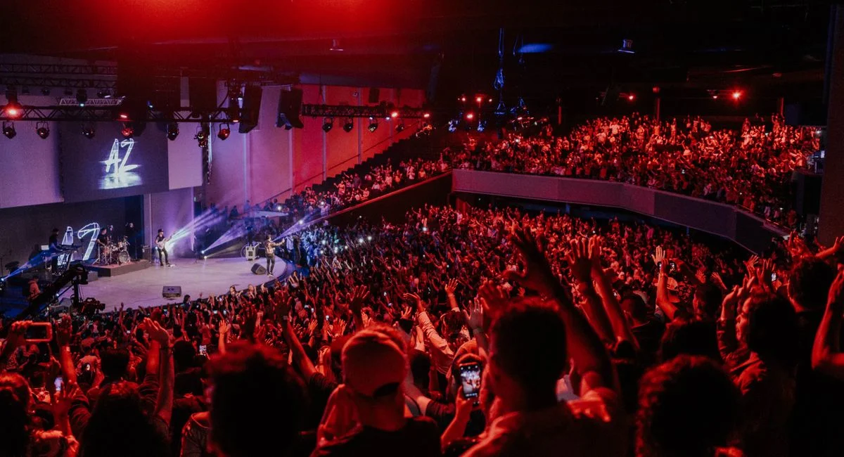 Vibrant live concert scene with an excited crowd under dramatic stage lighting.